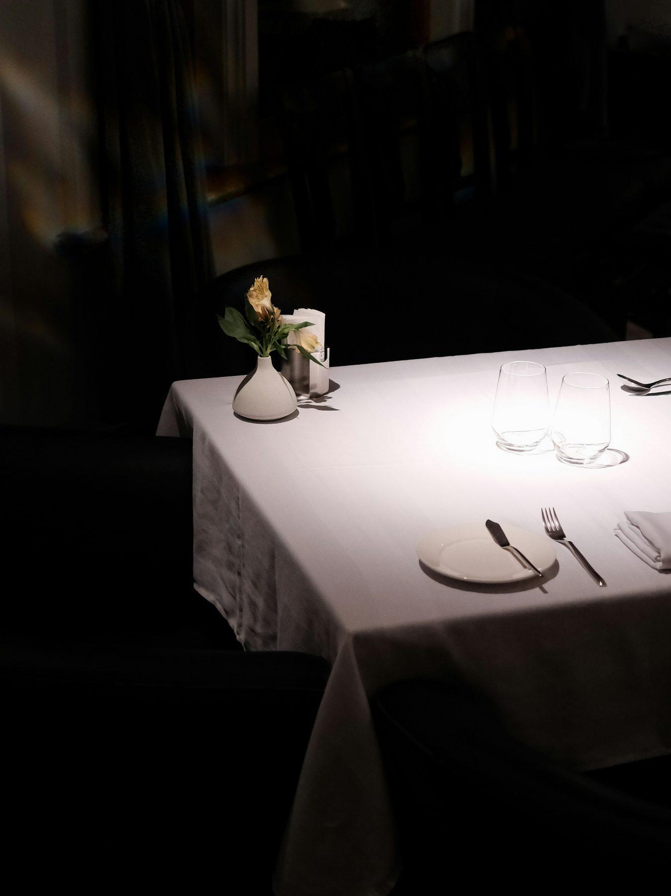 Table dressée dans la pénombre de la salle